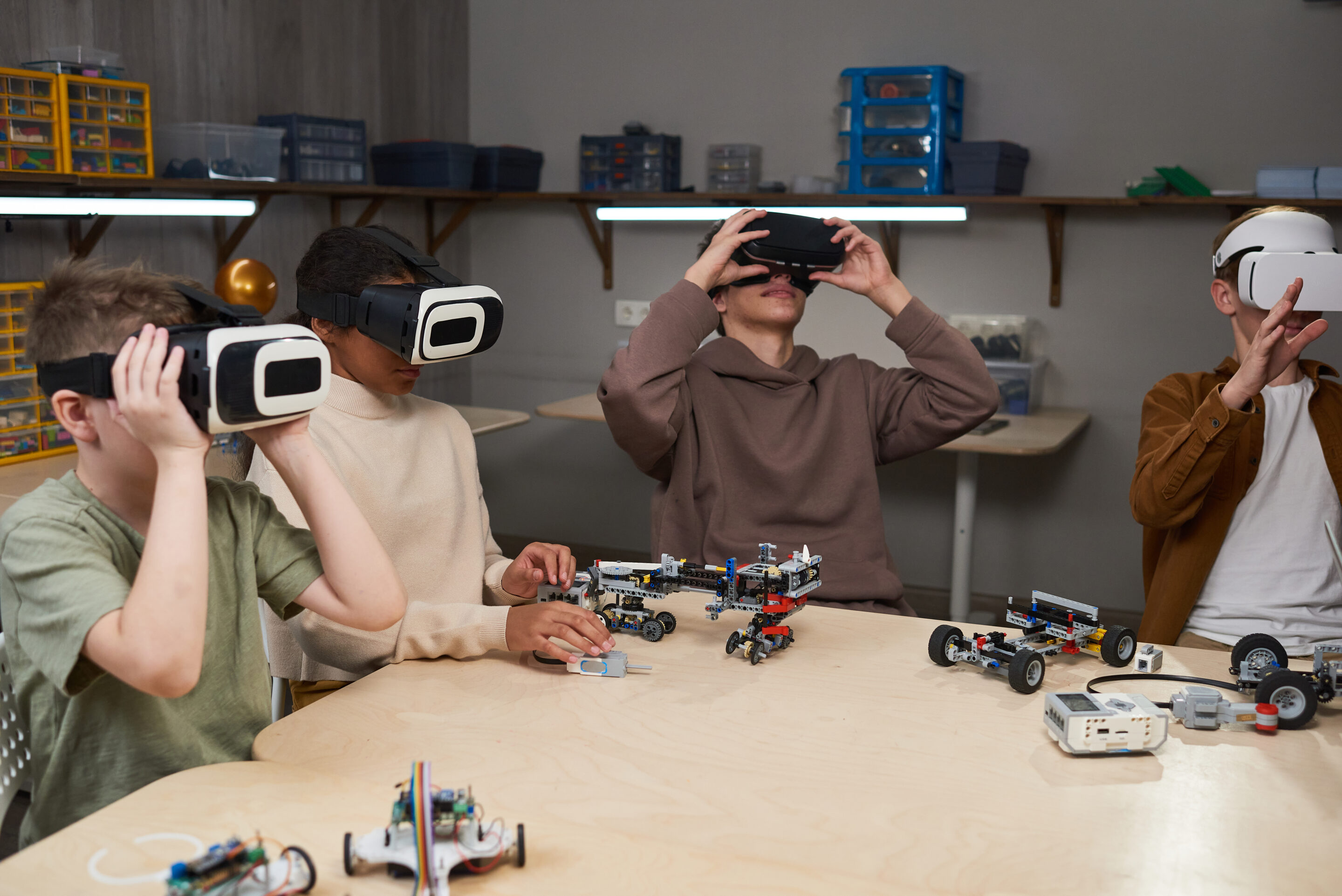 Jugendliche tragen VR-Brillen und bauen Roboter